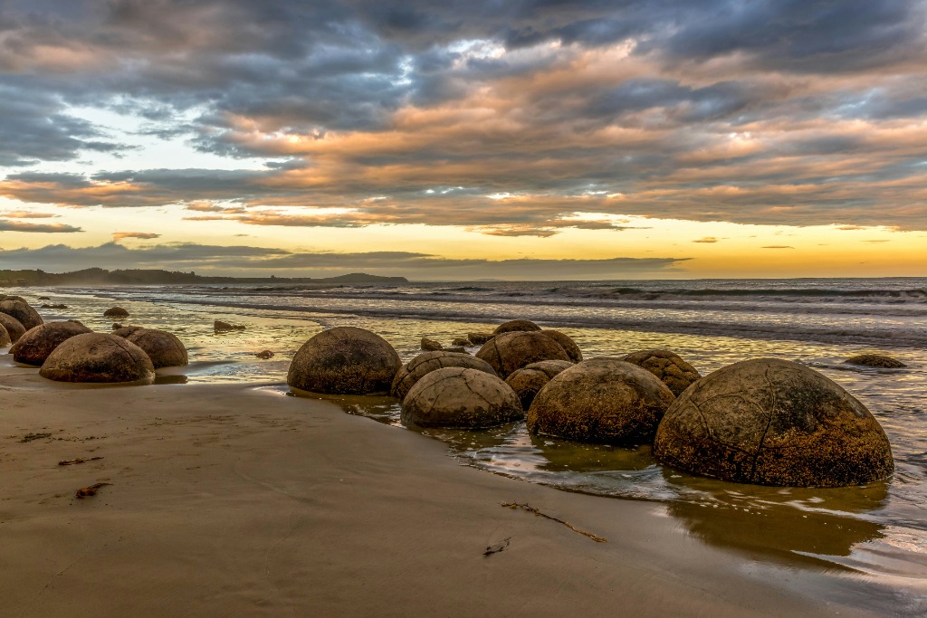 Ancient spherical Moeraki Boulders strewn along the Pacific coastline of Otago
